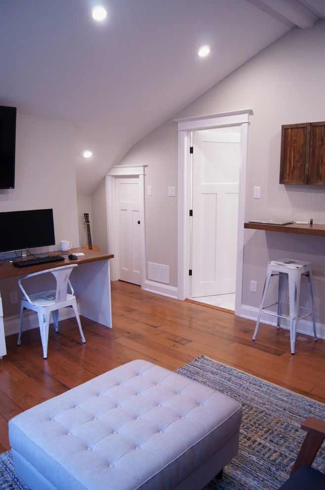 This is an example of a large traditional study in Ottawa with grey walls, medium hardwood flooring, a built-in desk and no fireplace.