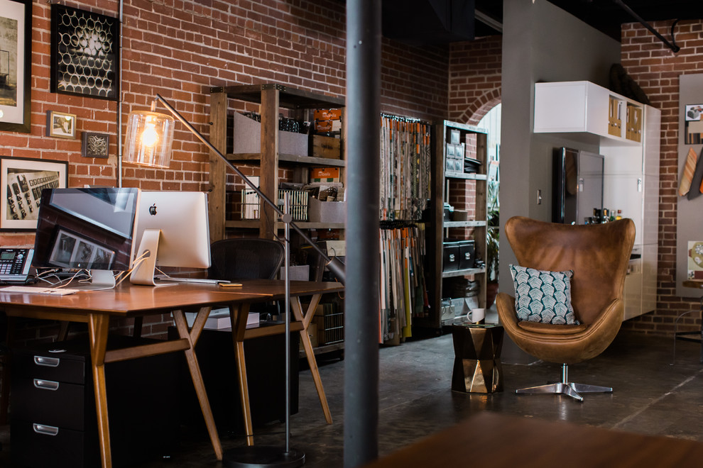 Cette photo montre un bureau industriel de taille moyenne et de type studio avec un mur gris, sol en béton ciré et un bureau indépendant.