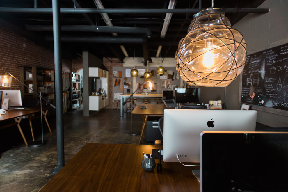 Mittelgroßes Industrial Arbeitszimmer mit Studio, grauer Wandfarbe, Betonboden und freistehendem Schreibtisch in Atlanta