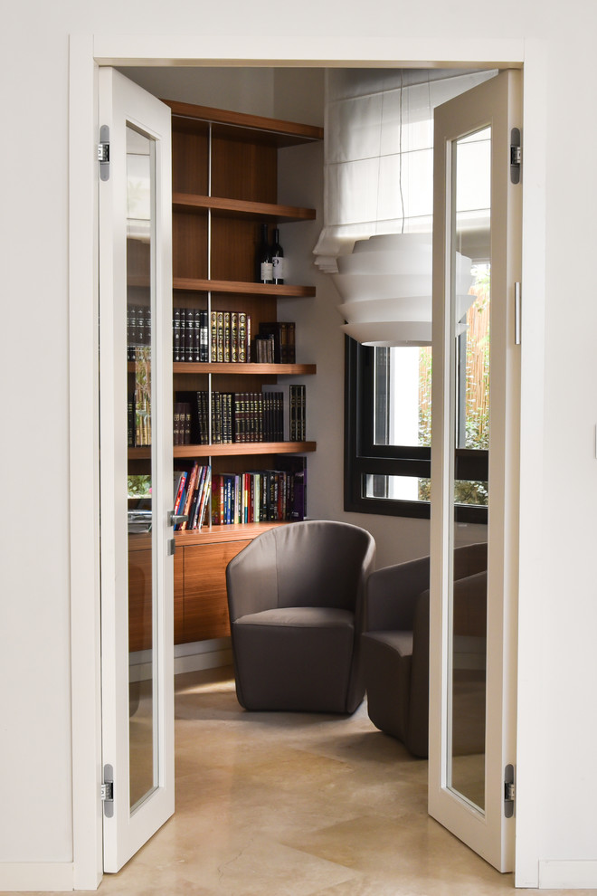Immagine di uno studio moderno con libreria, pareti bianche e scrivania incassata