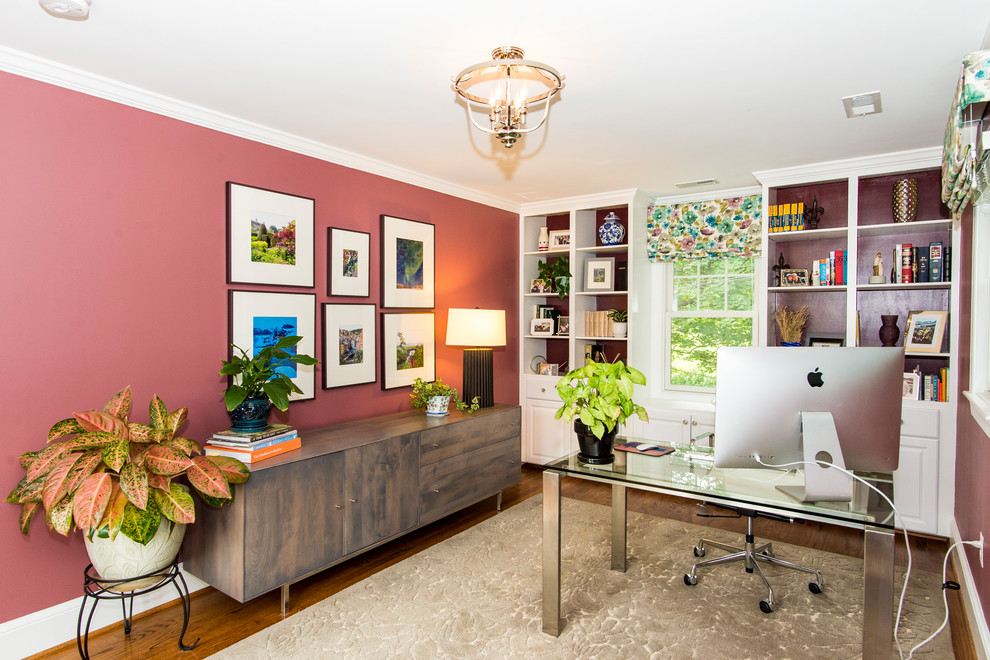 Mittelgroßes Klassisches Arbeitszimmer ohne Kamin mit Arbeitsplatz, rosa Wandfarbe, braunem Holzboden, freistehendem Schreibtisch und braunem Boden in Washington, D.C.