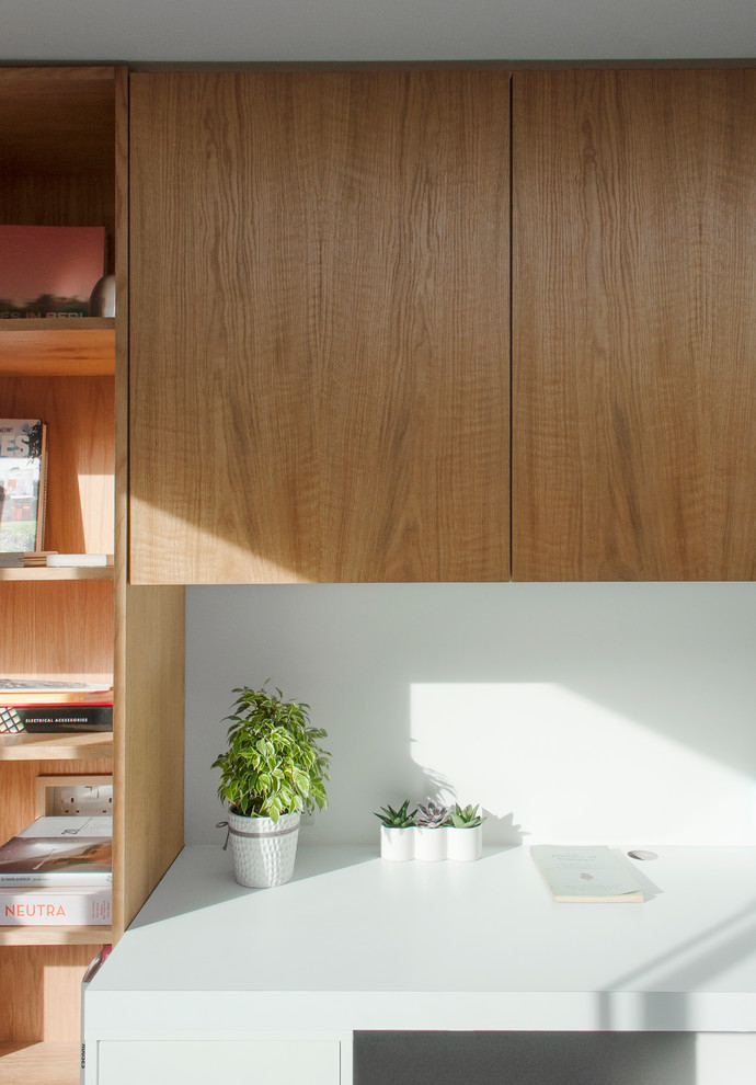 Inredning av ett minimalistiskt litet hemmabibliotek, med skiffergolv och ett inbyggt skrivbord