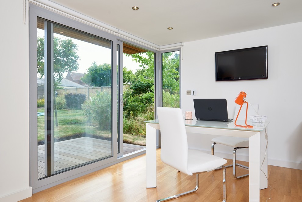 Small contemporary home studio in West Midlands with white walls and a freestanding desk.