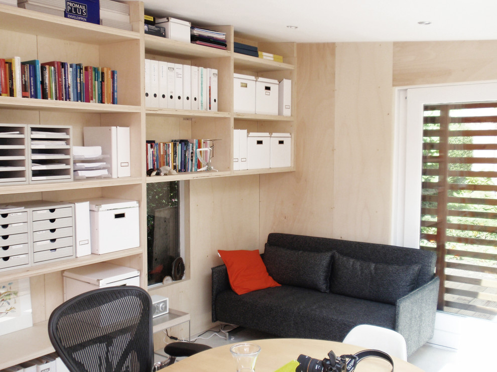 Idee per un piccolo studio design con libreria e pavimento in linoleum