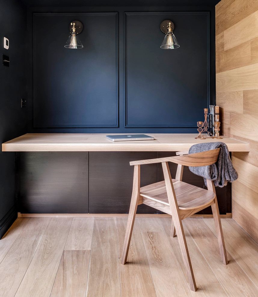 На фото: кабинет в современном стиле с черными стенами, светлым паркетным полом и встроенным рабочим столом с