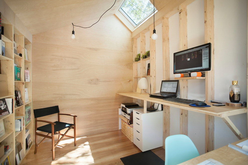 Idéer för små industriella hemmabibliotek, med flerfärgade väggar, ljust trägolv, ett inbyggt skrivbord och brunt golv