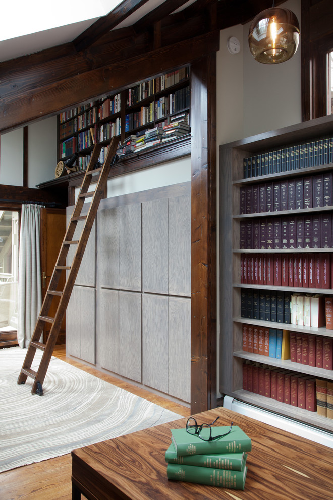 Großes Modernes Lesezimmer mit beiger Wandfarbe, braunem Holzboden, freistehendem Schreibtisch, braunem Boden und Holzwänden in New York