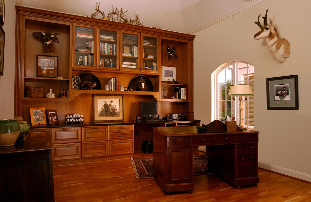 Foto de despacho clásico grande con paredes blancas, suelo de madera en tonos medios y escritorio independiente