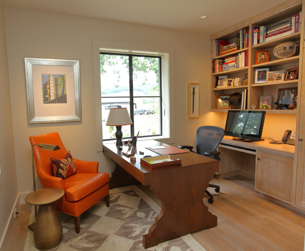 Idéer för mellanstora vintage hemmabibliotek, med beige väggar, ljust trägolv och ett fristående skrivbord
