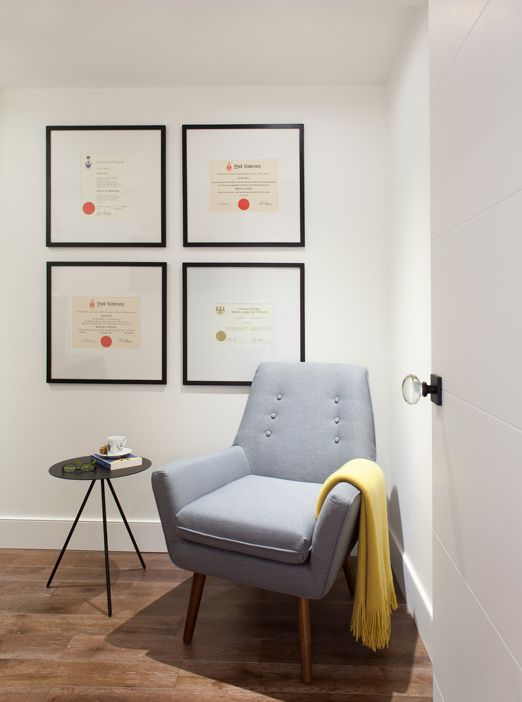 Immagine di uno studio minimal con pareti bianche, parquet chiaro, scrivania autoportante e pavimento bianco