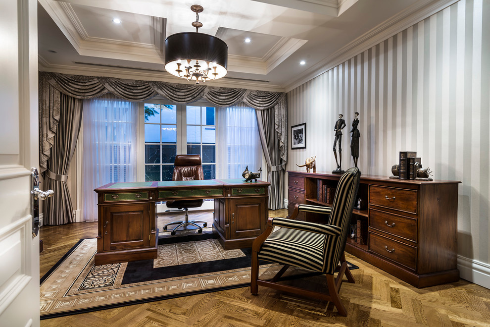 Imagen de despacho tradicional con suelo de madera en tonos medios y escritorio independiente