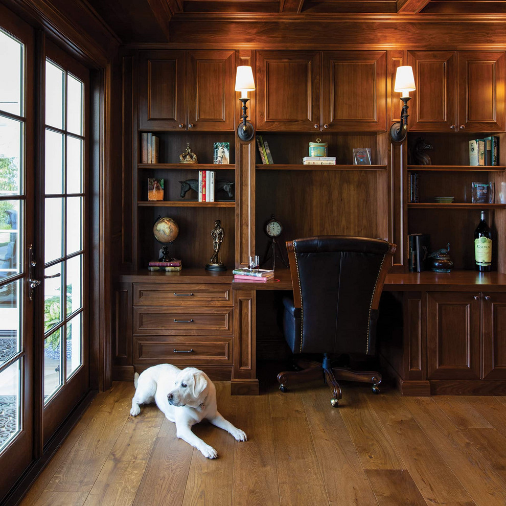 Cette image montre un bureau traditionnel avec un sol en bois brun, un bureau intégré et un sol marron.
