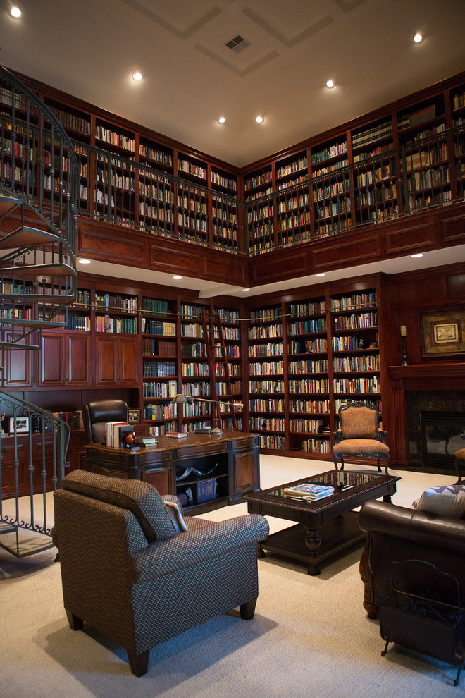 На фото: огромный домашняя библиотека в классическом стиле с коричневыми стенами, ковровым покрытием, стандартным камином, фасадом камина из плитки, отдельно стоящим рабочим столом и серым полом