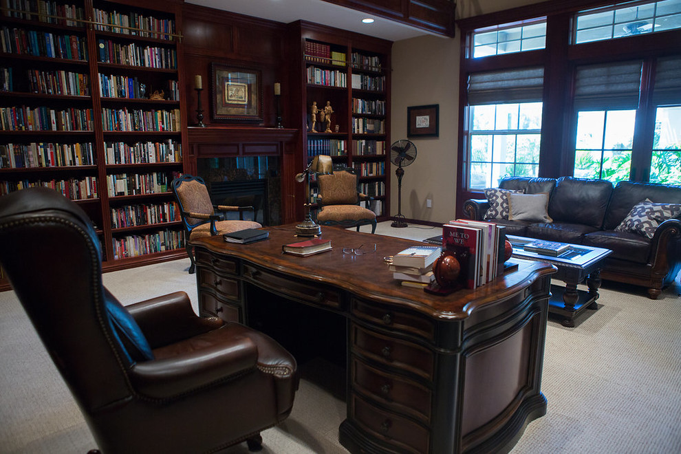 Ejemplo de despacho clásico extra grande con biblioteca, paredes marrones, moqueta, todas las chimeneas, marco de chimenea de baldosas y/o azulejos, escritorio independiente y suelo gris