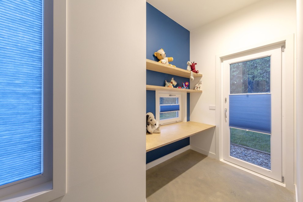 Mittelgroßes Modernes Arbeitszimmer mit Arbeitsplatz, blauer Wandfarbe, Betonboden, Einbau-Schreibtisch und grauem Boden in Canberra - Queanbeyan