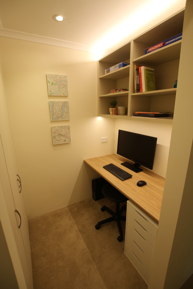 Esempio di un piccolo ufficio design con pareti beige, moquette, scrivania incassata e pavimento beige
