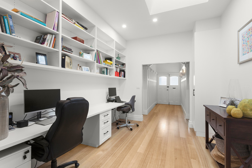 Idee per un piccolo ufficio design con pareti bianche, parquet chiaro, scrivania incassata e pavimento beige