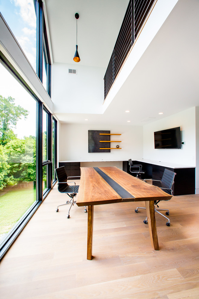 Inspiration för mellanstora moderna arbetsrum, med vita väggar, ljust trägolv, ett inbyggt skrivbord och brunt golv