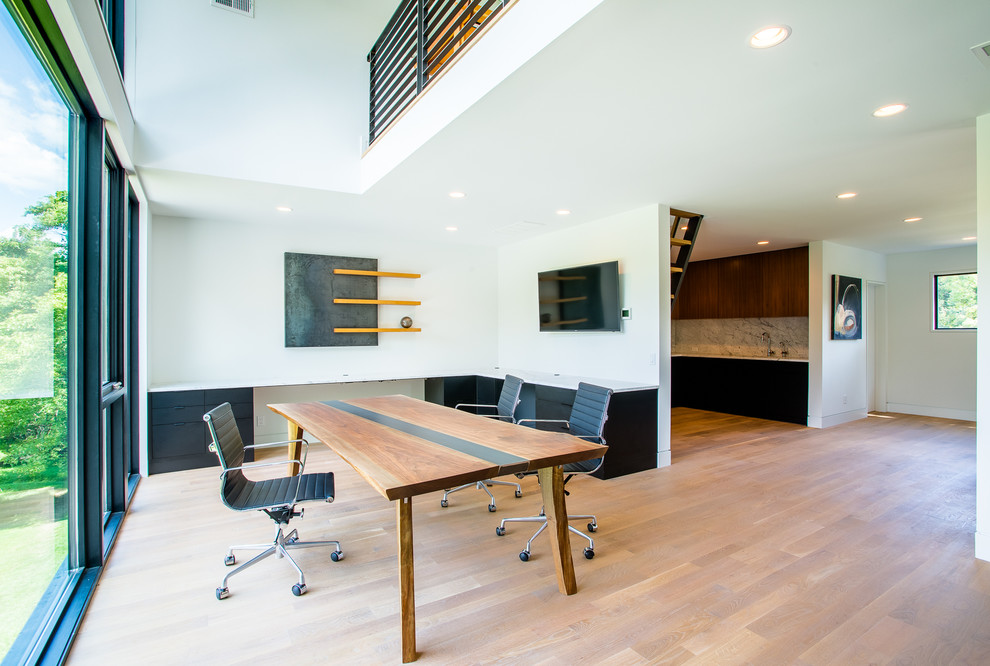 Idéer för att renovera ett mellanstort funkis arbetsrum, med vita väggar, ljust trägolv, ett inbyggt skrivbord och brunt golv