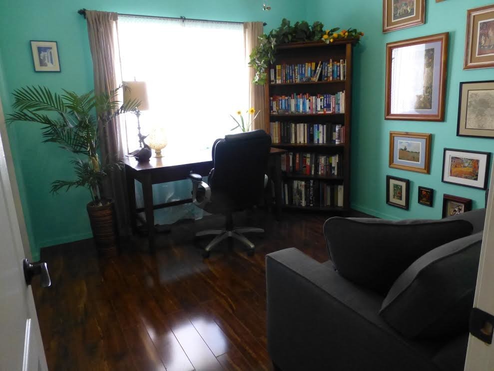Imagen de despacho bohemio de tamaño medio con paredes azules, suelo de madera oscura y escritorio independiente