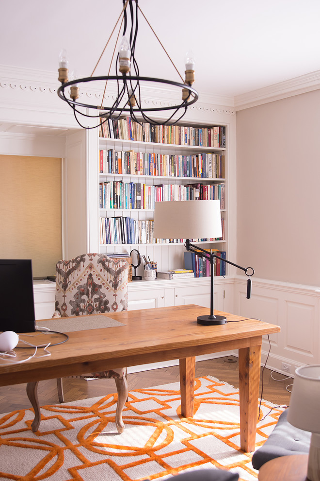 Cette image montre un bureau vintage de taille moyenne avec une bibliothèque ou un coin lecture, un mur beige, un sol en bois brun, un bureau indépendant et un sol gris.