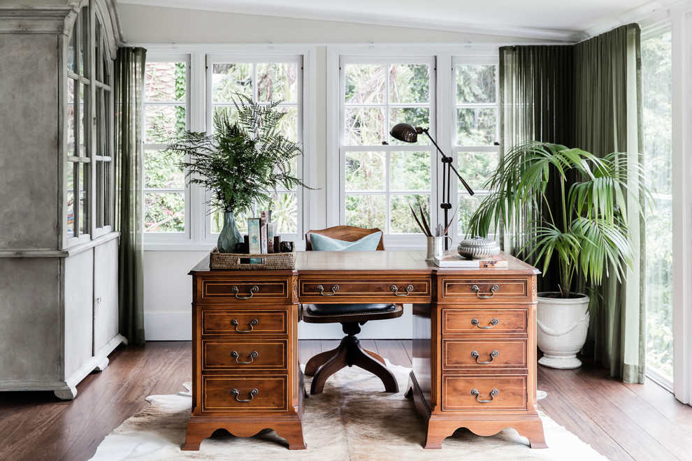 Modelo de despacho clásico grande con paredes beige, suelo de madera oscura y escritorio independiente
