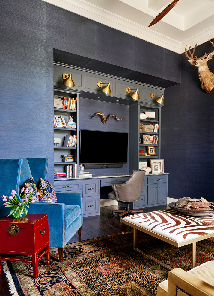オースティンにある高級な広いトランジショナルスタイルのおしゃれな書斎 (青い壁、濃色無垢フローリング、標準型暖炉、石材の暖炉まわり、造り付け机) の写真