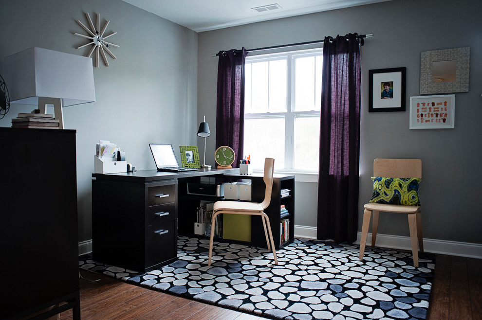 Großes Klassisches Arbeitszimmer ohne Kamin mit grauer Wandfarbe, dunklem Holzboden und freistehendem Schreibtisch in Sonstige