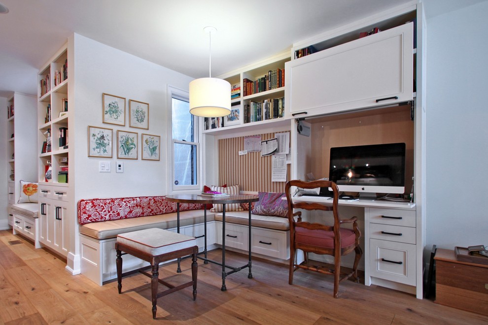 Diseño de despacho clásico de tamaño medio sin chimenea con paredes blancas, suelo de madera clara y escritorio empotrado