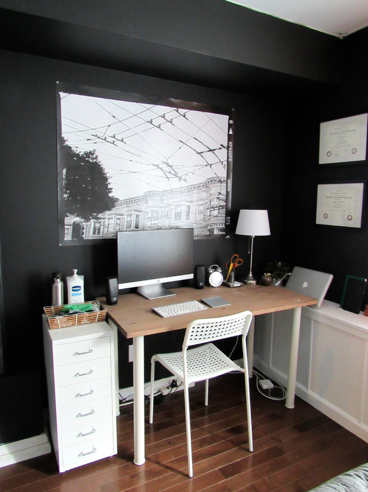 Kleines Stilmix Arbeitszimmer ohne Kamin mit Arbeitsplatz, schwarzer Wandfarbe, dunklem Holzboden und freistehendem Schreibtisch in San Francisco