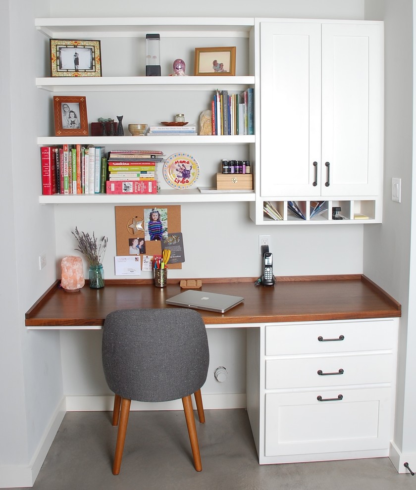 Diseño de despacho clásico de tamaño medio con paredes grises, suelo de cemento, escritorio empotrado y suelo gris