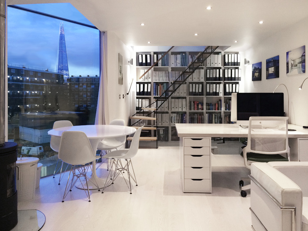 Diseño de estudio actual pequeño con paredes blancas, suelo de madera clara, estufa de leña y escritorio independiente