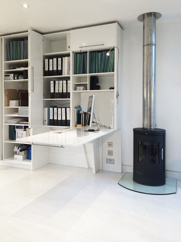 Kleines Modernes Arbeitszimmer mit Studio, weißer Wandfarbe, hellem Holzboden, Kaminofen und Einbau-Schreibtisch in London