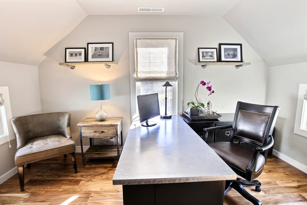 Modelo de despacho tradicional de tamaño medio con paredes grises, suelo de madera en tonos medios y escritorio independiente