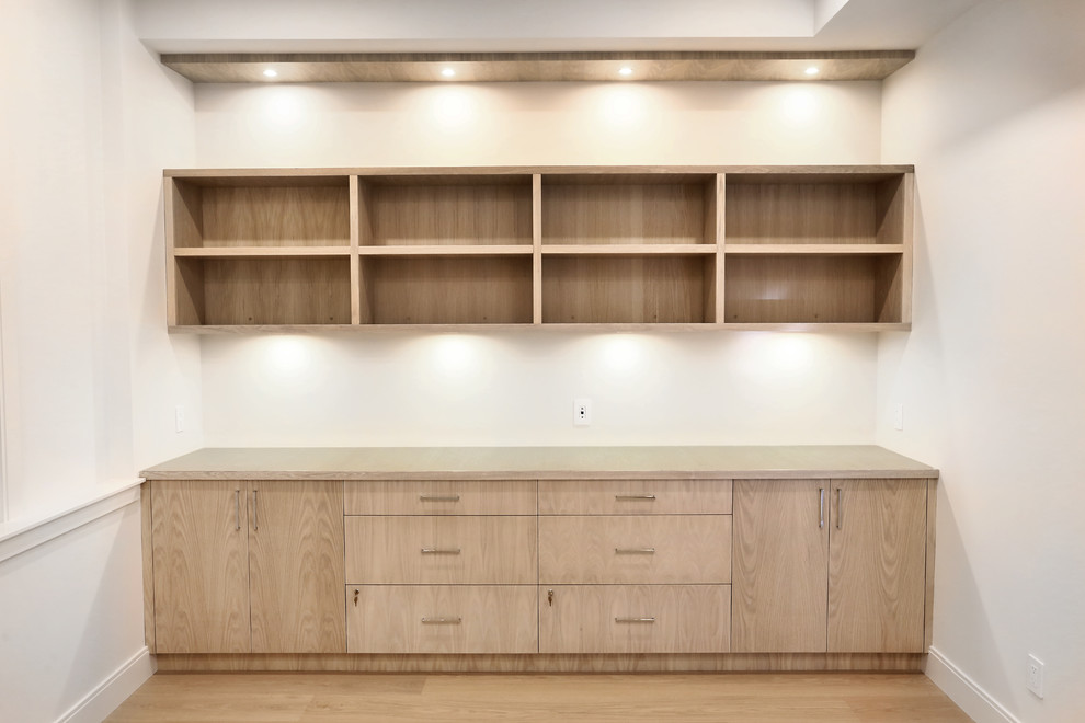 Foto de despacho actual de tamaño medio con paredes blancas, suelo de madera clara y suelo beige