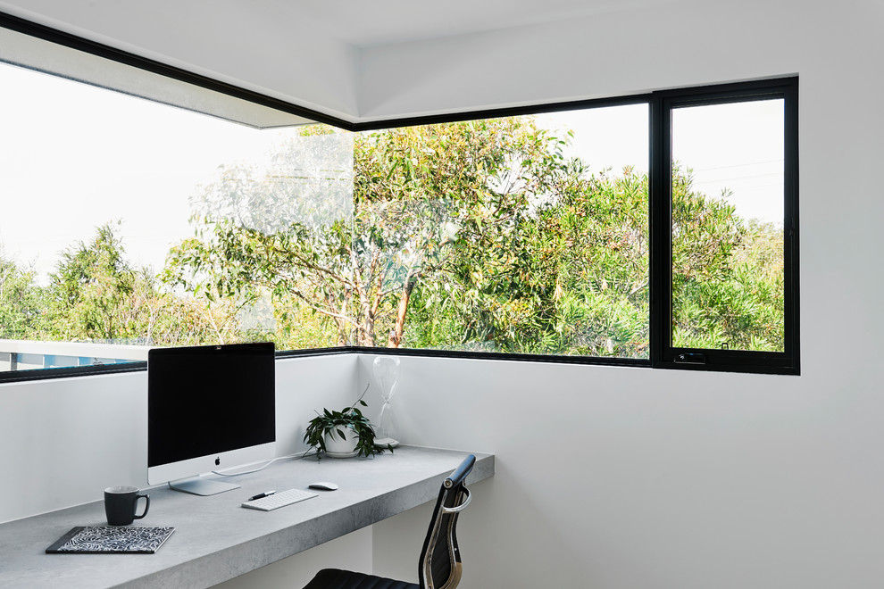 Mittelgroßes Modernes Arbeitszimmer mit Studio, weißer Wandfarbe, hellem Holzboden, Einbau-Schreibtisch und braunem Boden in Geelong