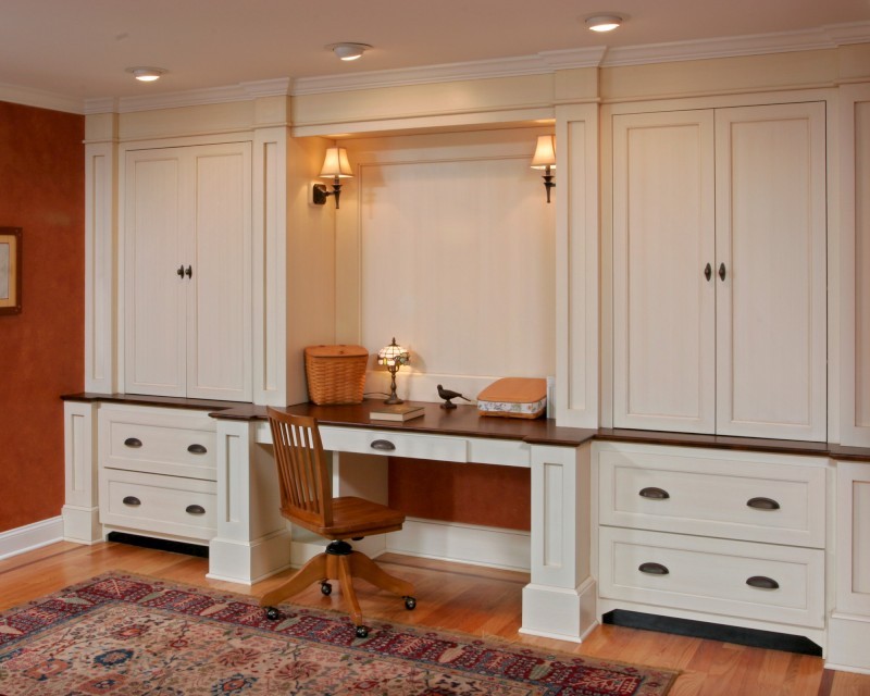 Ejemplo de despacho tradicional de tamaño medio con parades naranjas, suelo de madera clara y escritorio empotrado