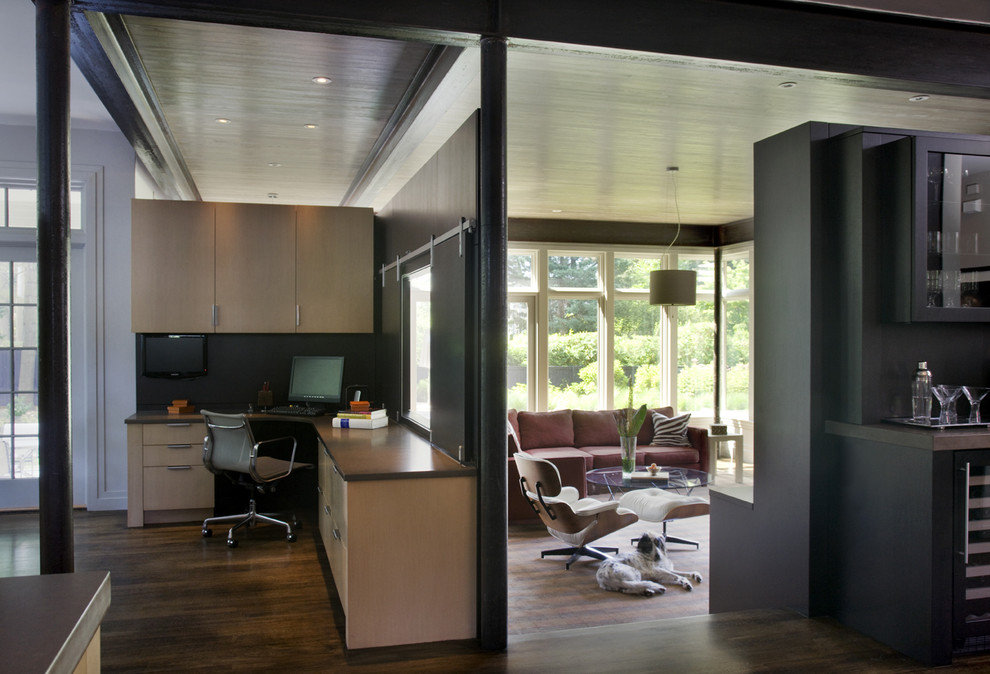 Idéer för ett modernt arbetsrum, med svarta väggar, mörkt trägolv och ett inbyggt skrivbord