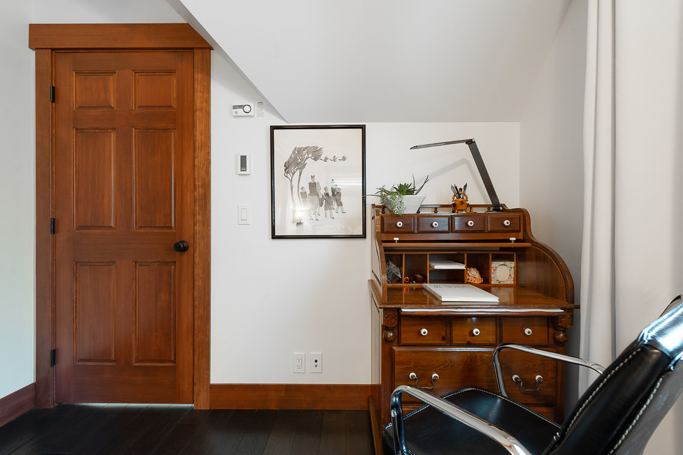 Elegant freestanding desk dark wood floor and brown floor home office photo in Seattle with white walls