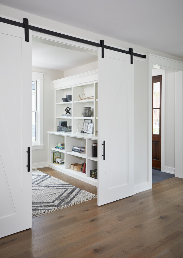 Imagen de despacho de estilo de casa de campo pequeño con paredes blancas y suelo de madera en tonos medios