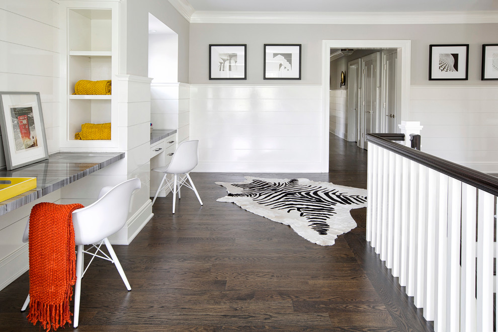 Traditional study in New York with grey walls, dark hardwood flooring and a built-in desk.