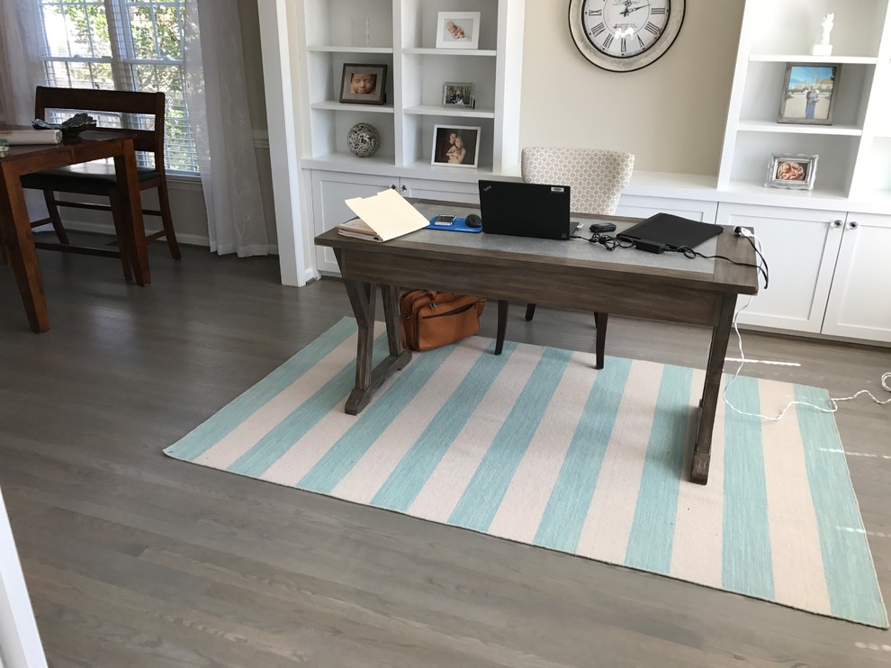 Imagen de despacho minimalista de tamaño medio con paredes grises, suelo de madera oscura, escritorio independiente y suelo gris