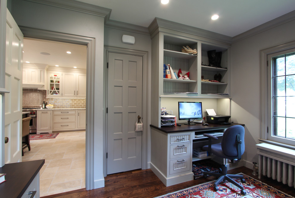 Inspiration pour un grand bureau traditionnel avec un mur gris, un sol en bois brun, un bureau intégré et un sol marron.