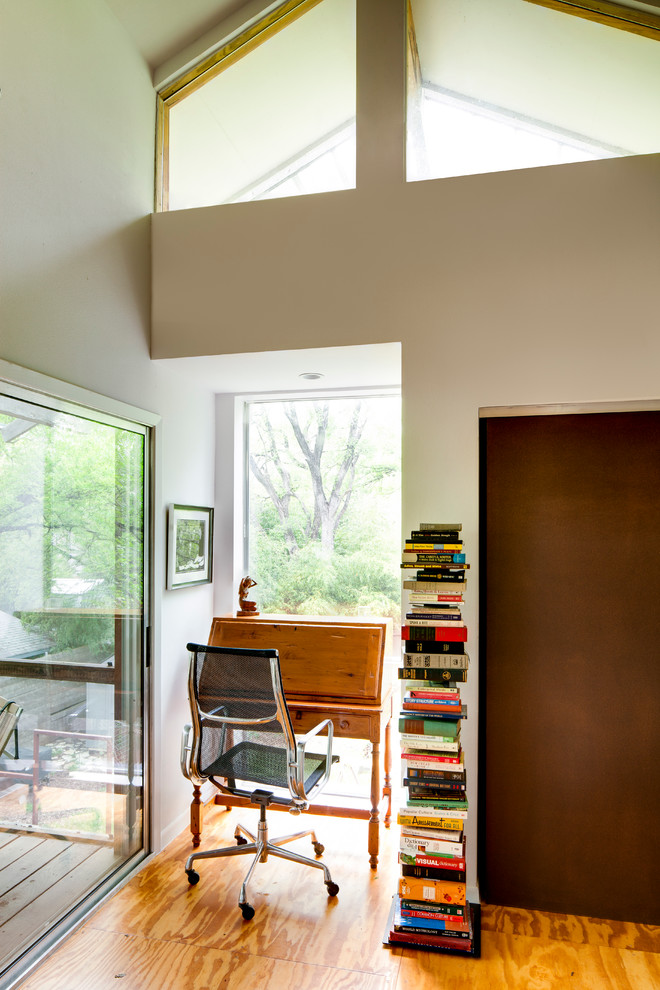 Diseño de despacho industrial con paredes beige, suelo de contrachapado y escritorio independiente