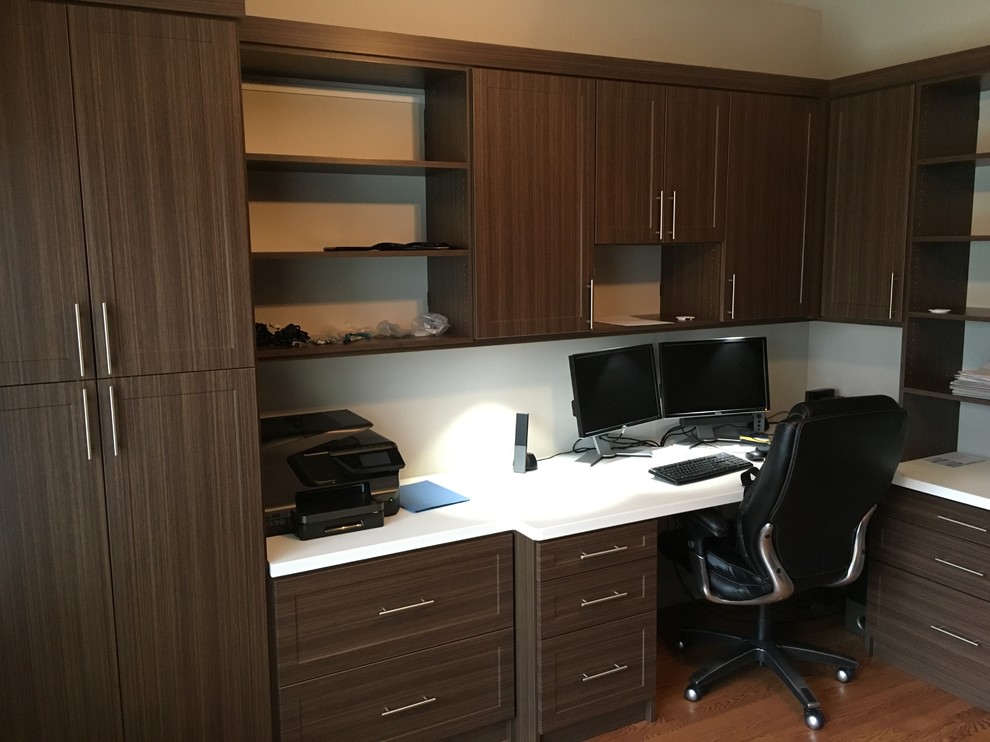 Modelo de despacho clásico renovado de tamaño medio sin chimenea con paredes blancas, suelo de madera clara y escritorio empotrado