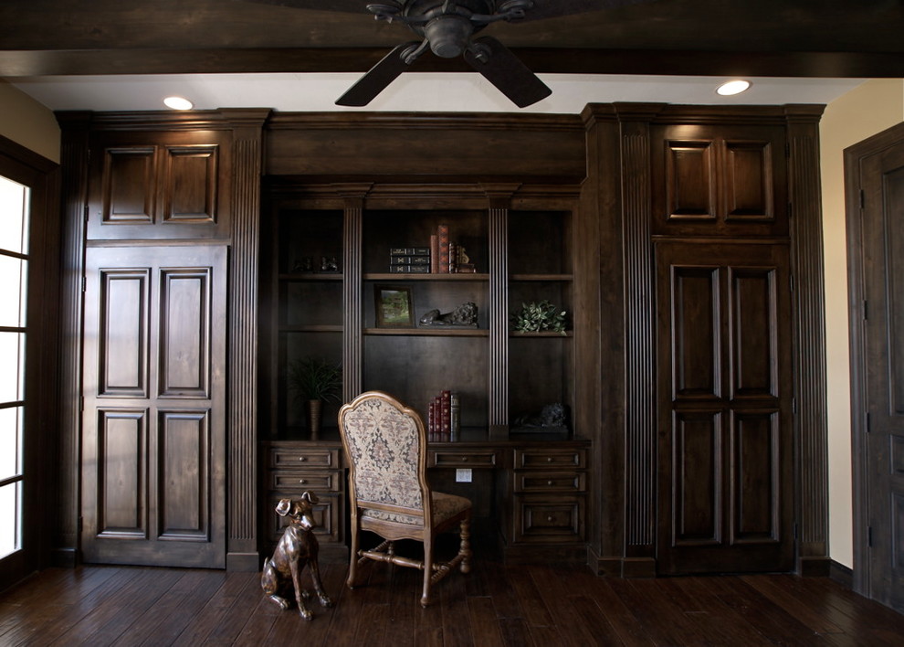 Imagen de despacho clásico grande con paredes beige, suelo de madera oscura y escritorio empotrado