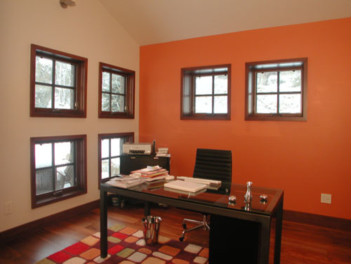 Idéer för att renovera ett mellanstort funkis arbetsrum, med orange väggar, mellanmörkt trägolv, ett fristående skrivbord och beiget golv