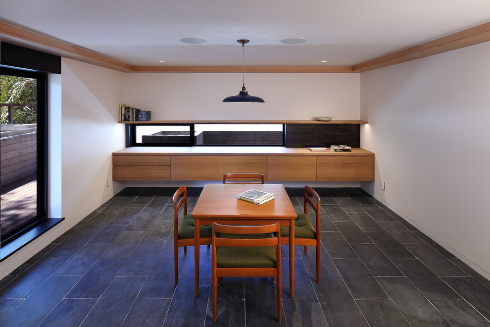 This is an example of a large contemporary dining room in San Francisco with white walls, slate flooring, no fireplace and grey floors.