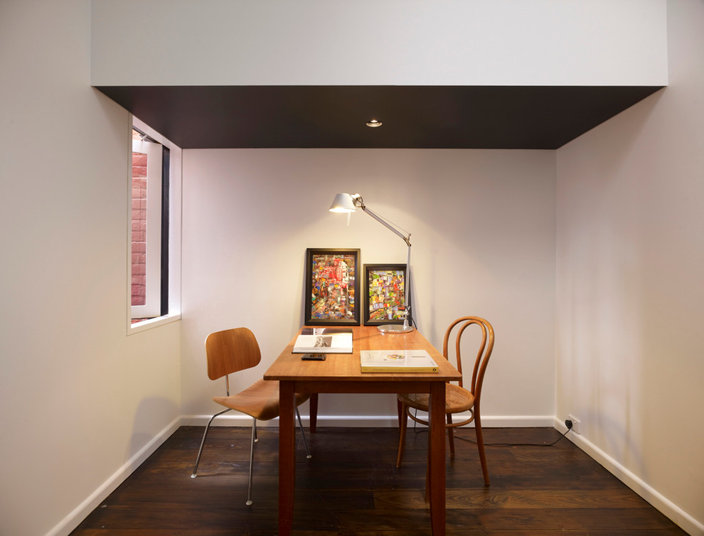 Home office - modern freestanding desk dark wood floor home office idea in Sydney with white walls and no fireplace