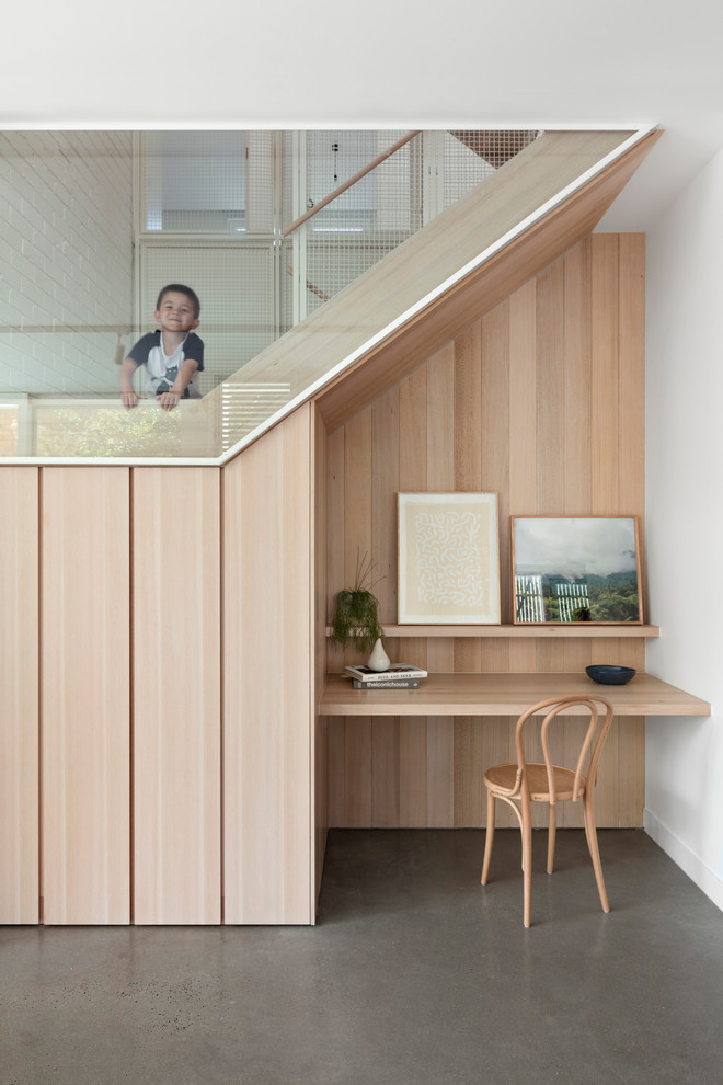 Kleines Skandinavisches Arbeitszimmer ohne Kamin mit Arbeitsplatz, weißer Wandfarbe, Betonboden, Einbau-Schreibtisch und grauem Boden in Melbourne